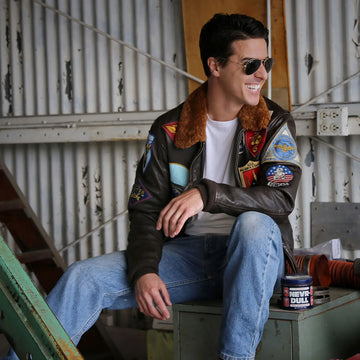 Men's brown leather bomber jacket with shearling collar and aviation patches